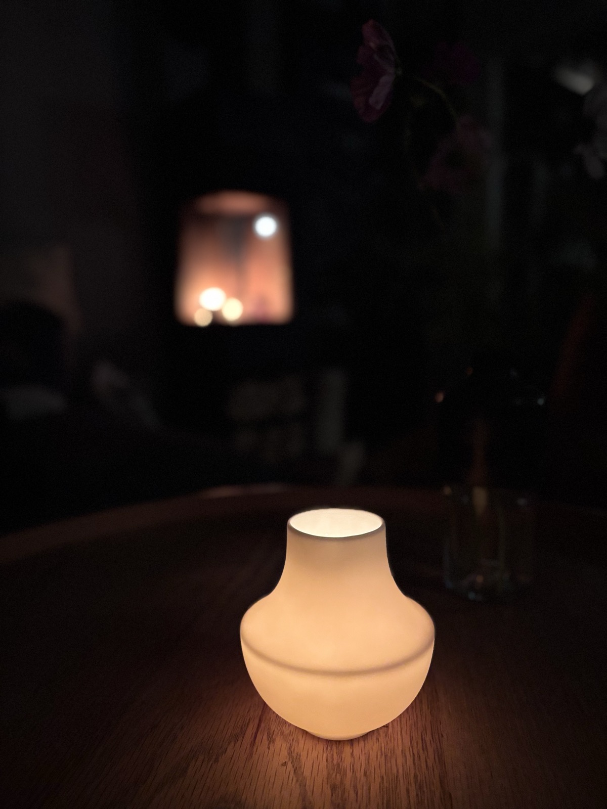casting: brennendes Windlicht auf einem Holztisch bei Dunkelheit